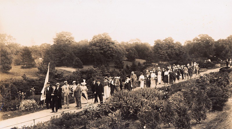 image of a gathering of people walking through a the New York botanical Garden